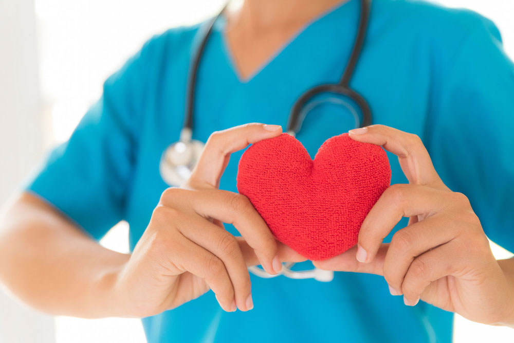 Nurse holds a plush heart 