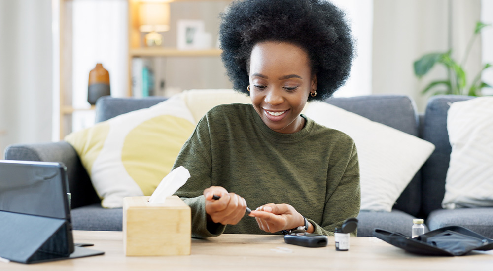 woman testing with blood sugar monitor at table