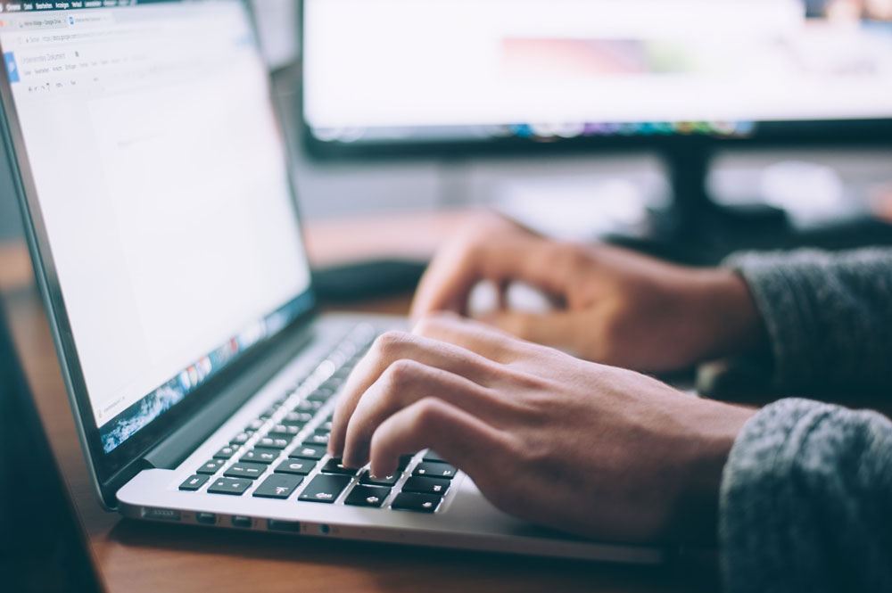 close up of hands on computer