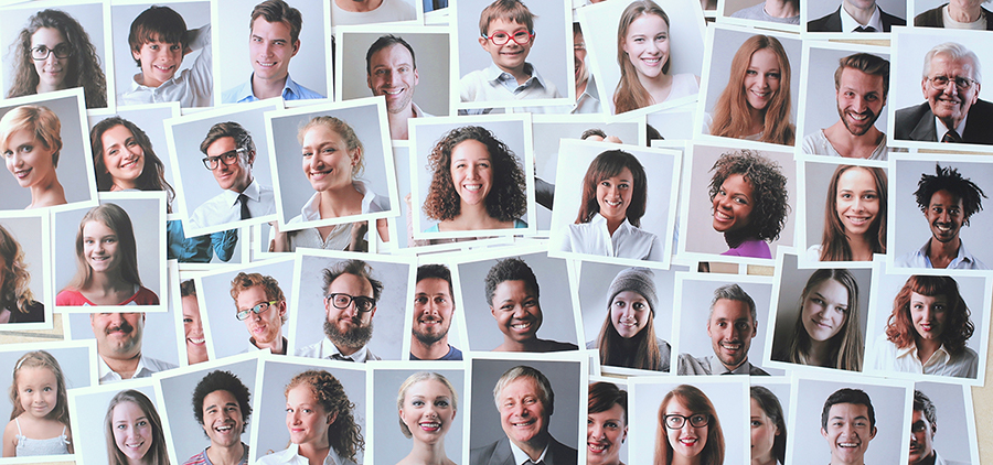 Multiple headshots of people of different ethnicities are spread out on a surface