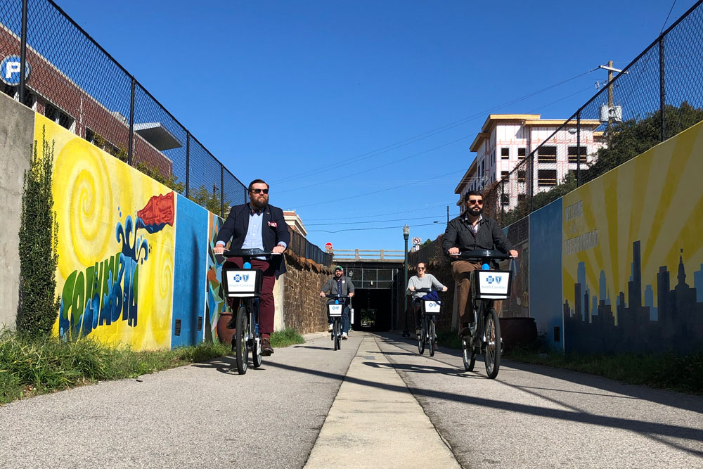 group of people riding blue bikes through tunnel