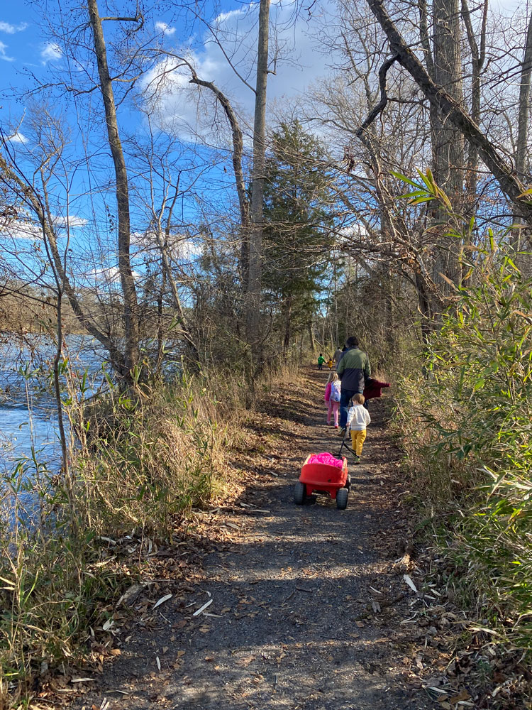 kid pulling red wagon on trail