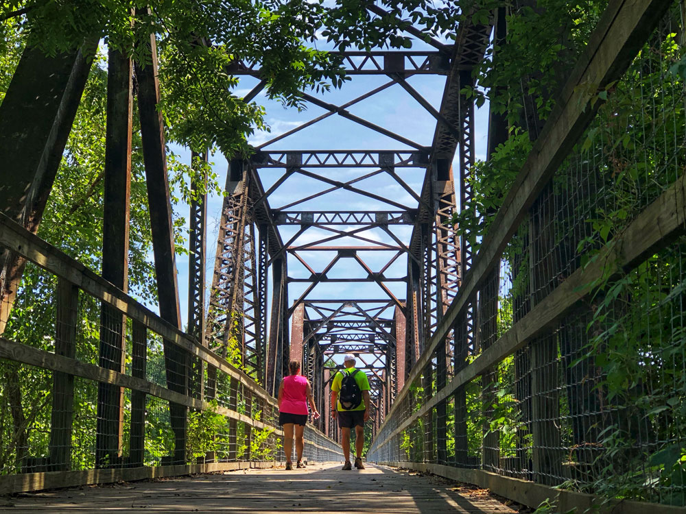 man and woman with backpacks hike on Palmetto Trail