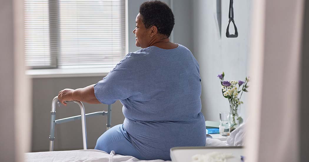 woman sitting on hospital bed in hospital gown