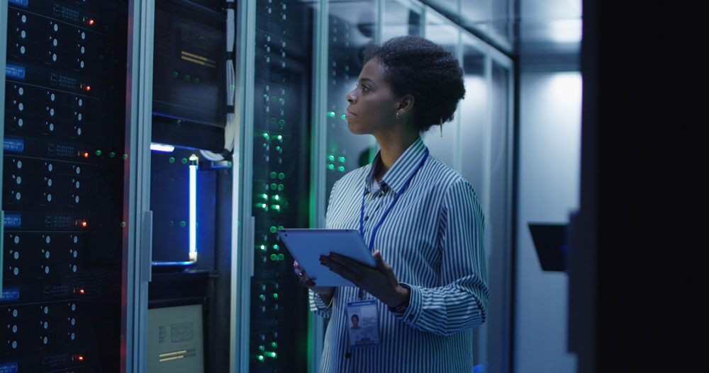 woman walks among databases in technology center